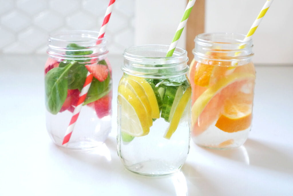 Three glasses of fruit and vegetable infused water.